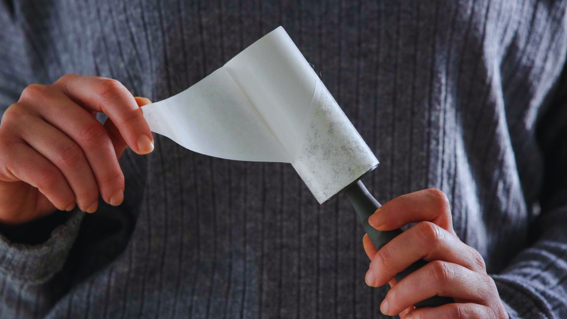 A person holds a piece of paper in one hand and a knife in the other, focused on the paper's content.