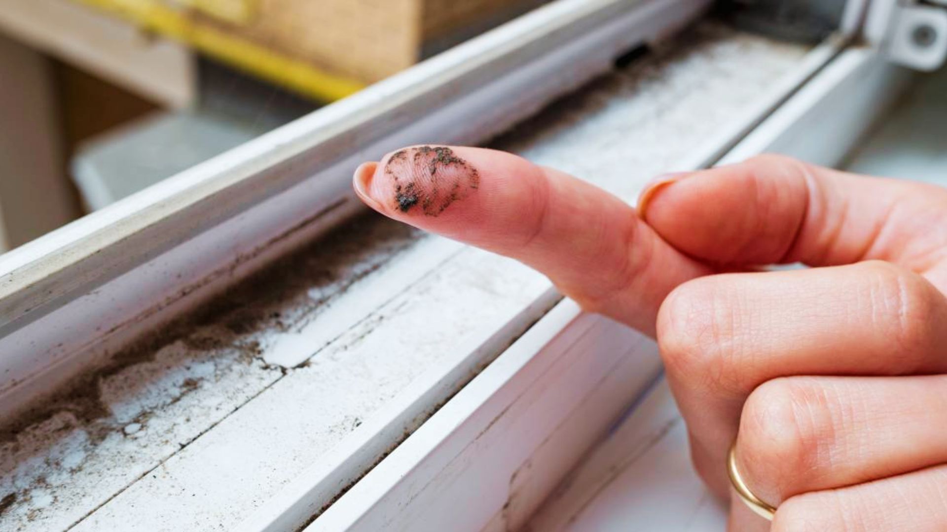 Finger with black grime showing how dirty window tracks get before starting the cleaning process