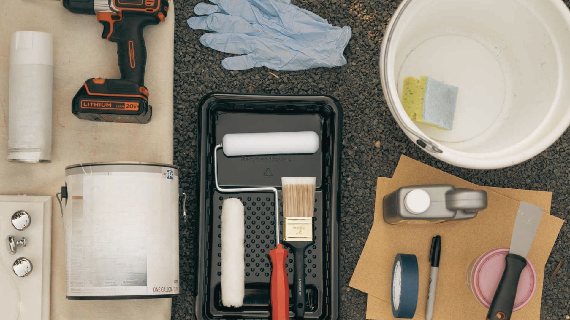 Flat lay of refinishing supplies: paint, drill, gloves, brushes, sandpaper, tape, and cleaning tools.