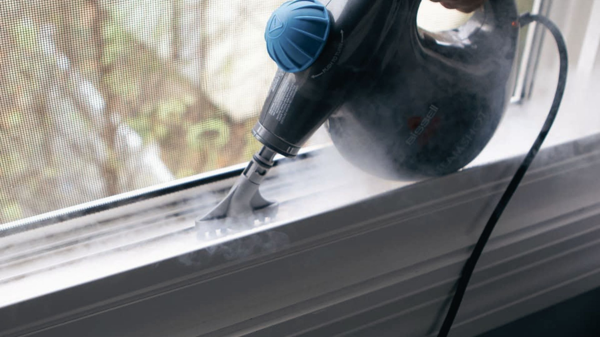 Using a steam cleaner with nozzle attachment to loosen dirt and grime from dirty window tracks.