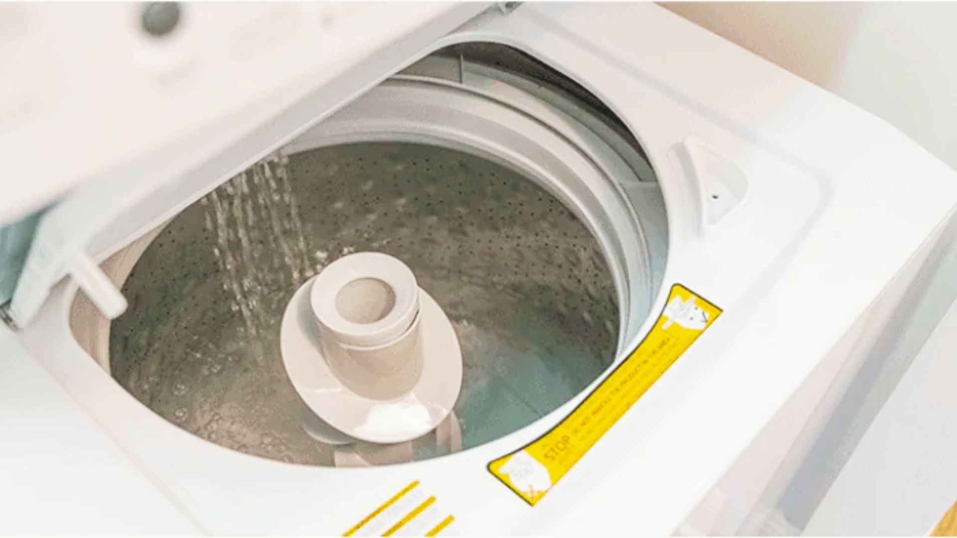 Top-load washer filling with water, showing potential agitator bearing squeak issue.