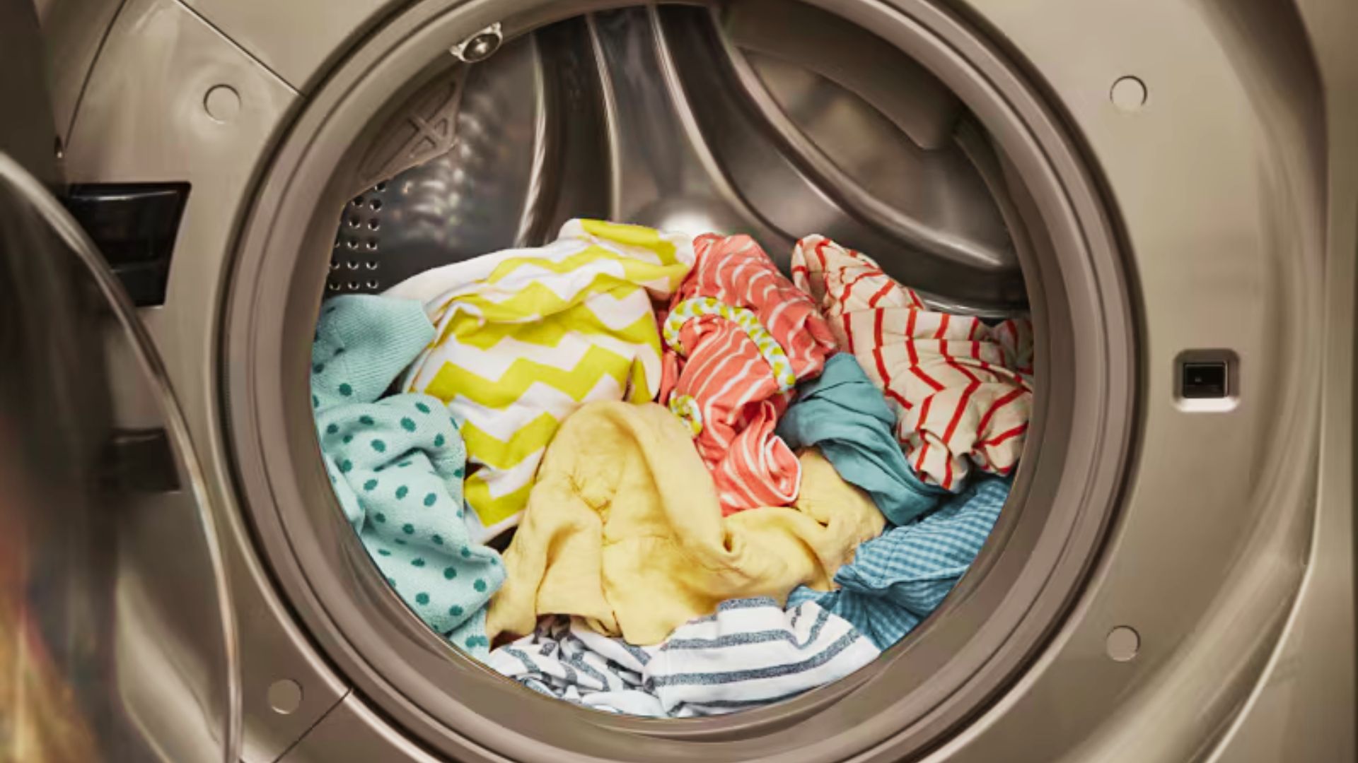 Front-load washing machine filled with mixed colorful clothes showing light soil level, suitable for a quick wash cycle.
