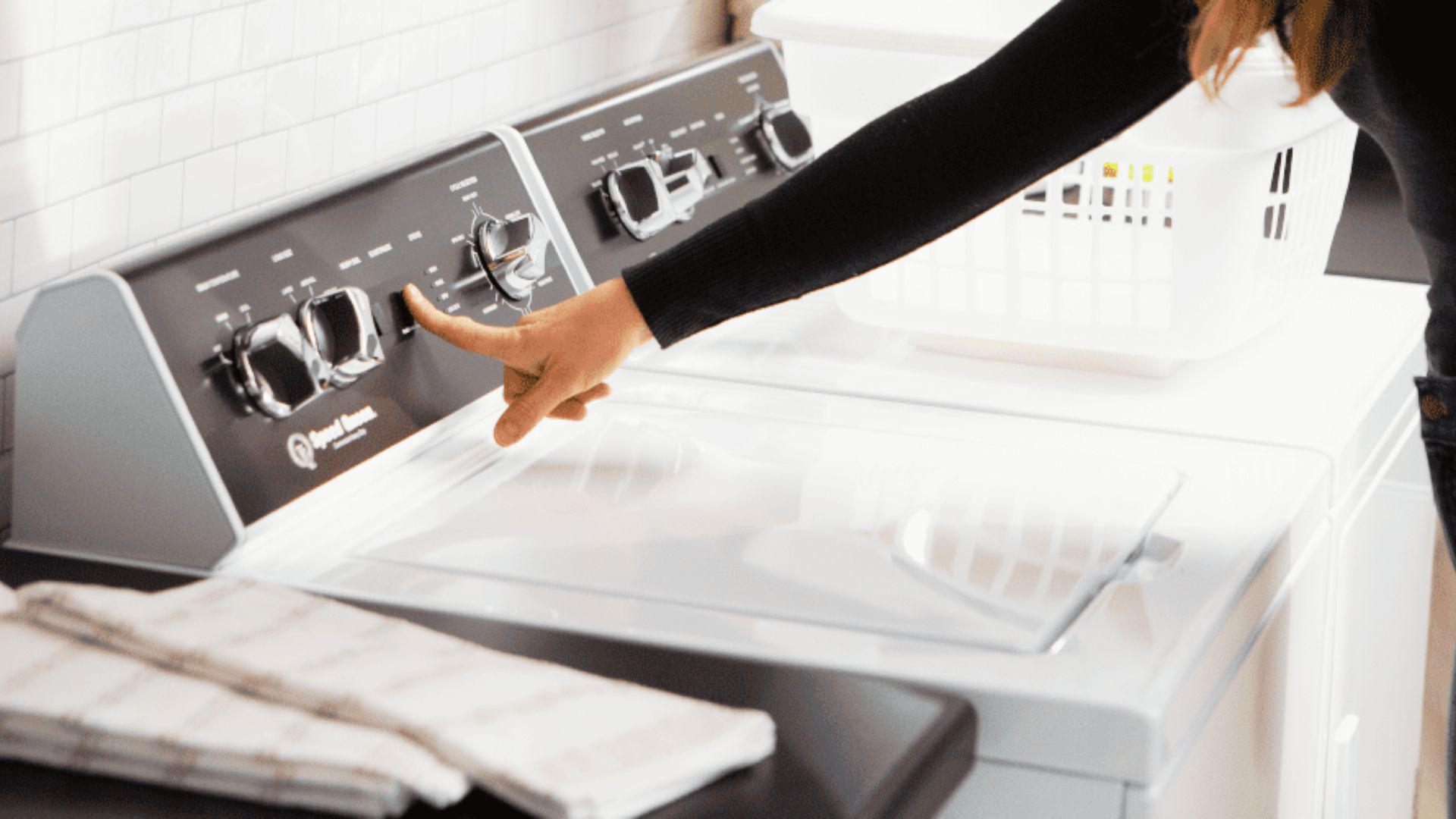 Hand selecting extra rinse and spin options on a top-load washing machine control panel for a quick wash.