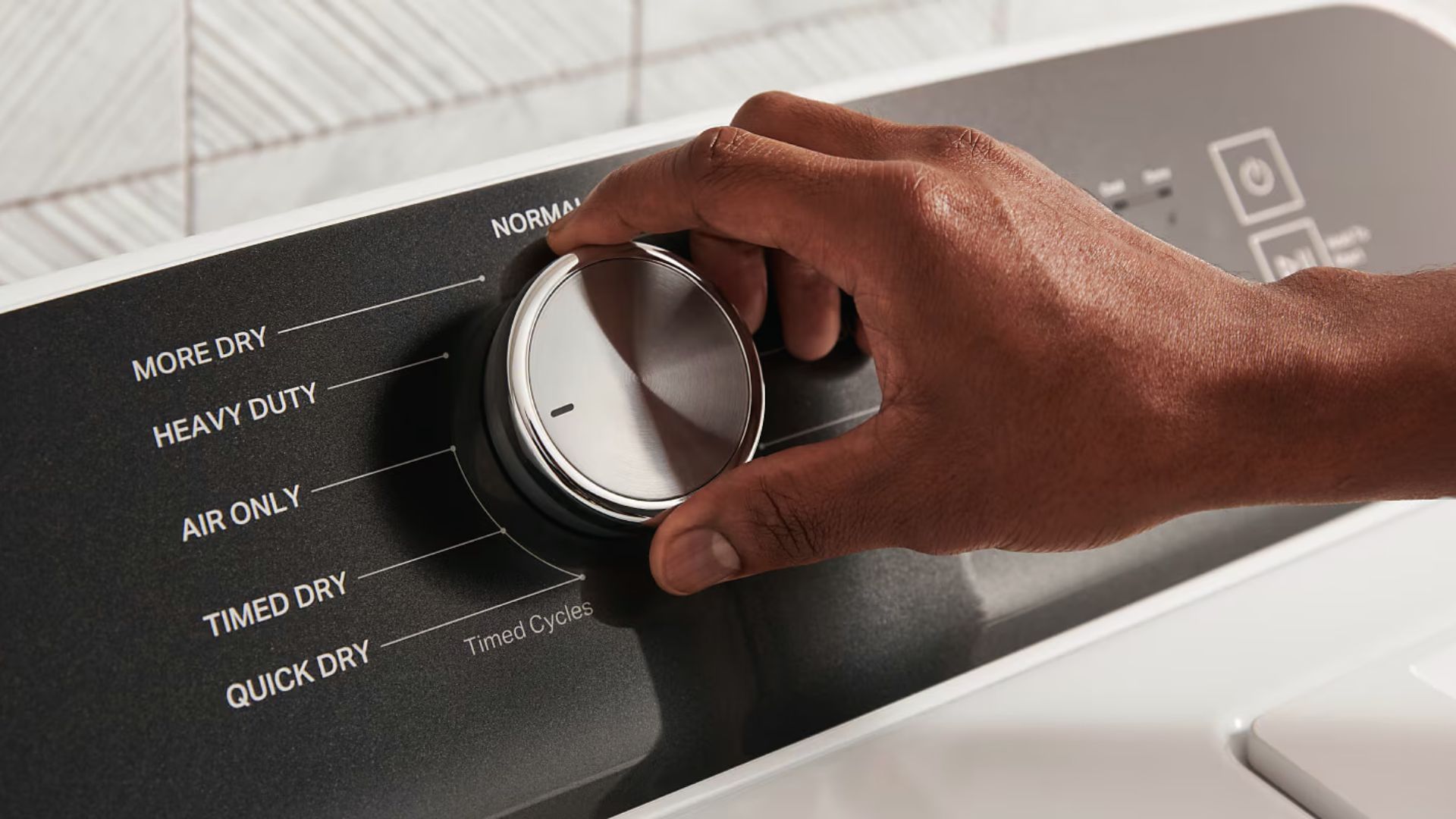 Hand turns a dryer dial to select gentle cycles like Air Only or Timed Dry.