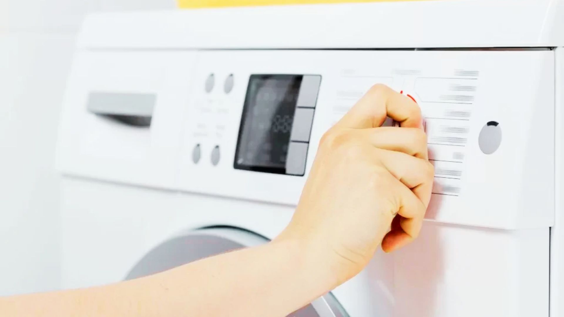 Hand adjusting a washing machine cycle selector dial to choose the quick wash option.