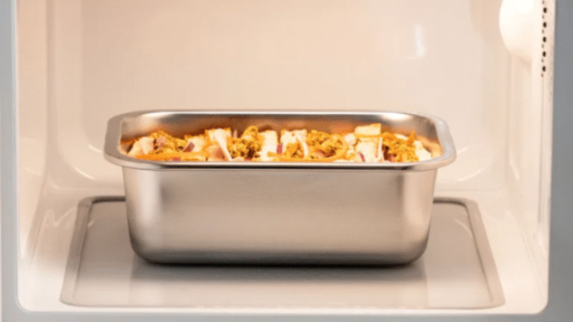 A microwave with a plate of food inside, showcasing a meal being heated.