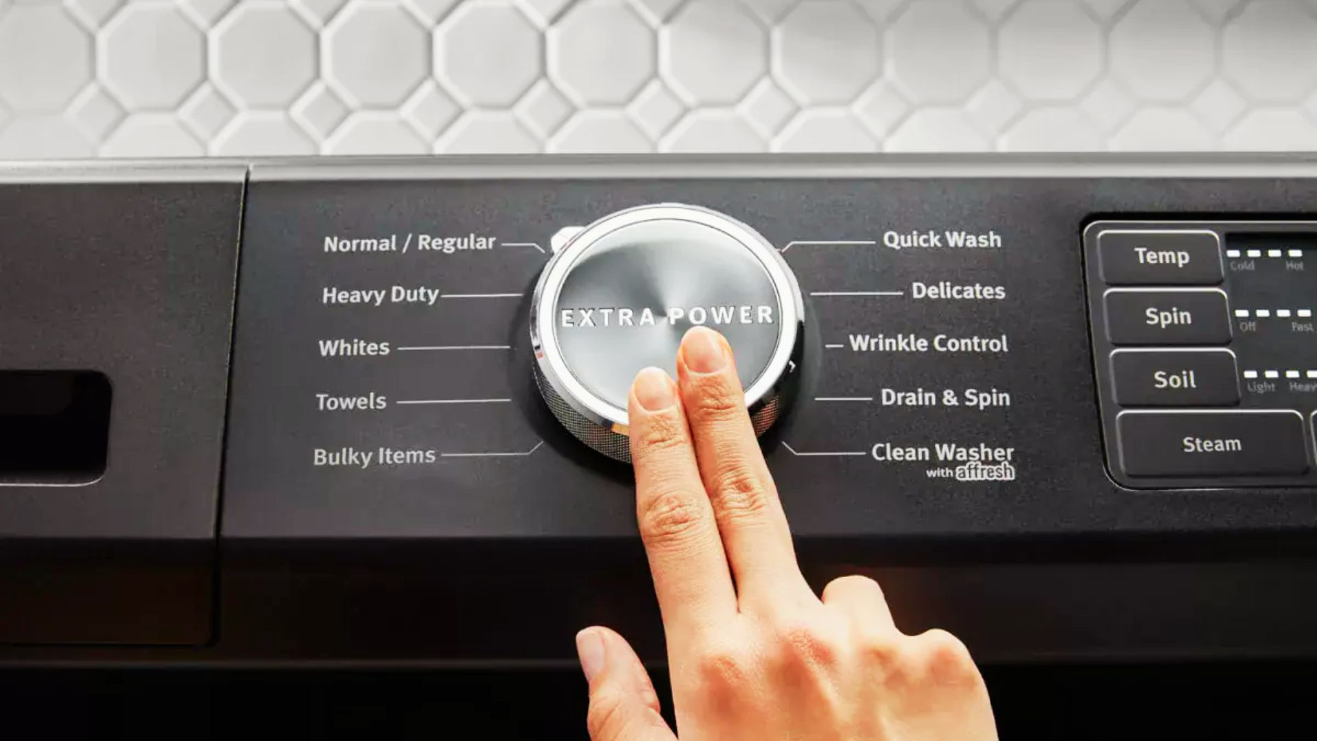 Hand turning a washer dial to the Quick Wash setting, which typically lasts 15 to 30 minutes.