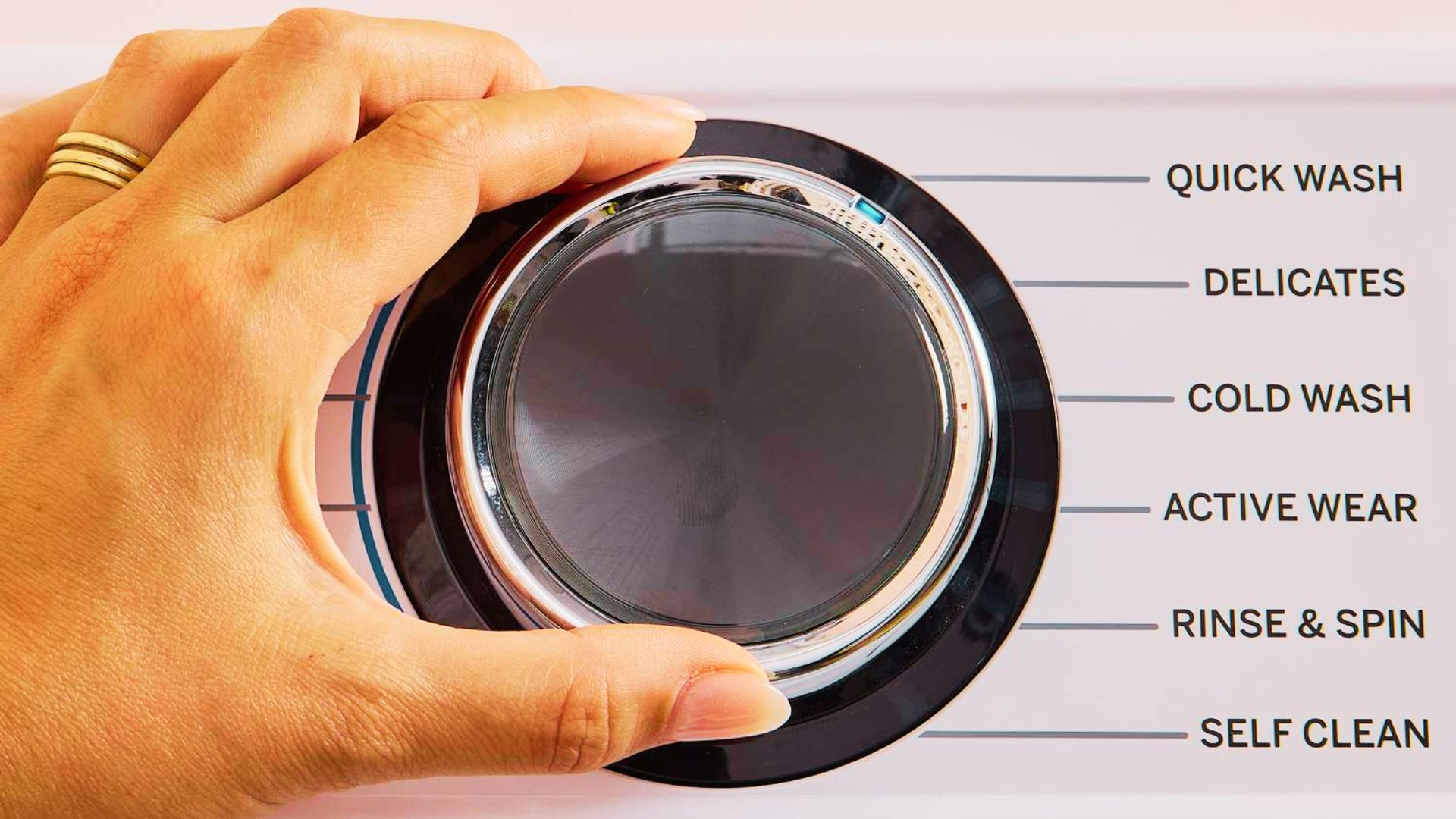 Finger selecting the Express cycle on a washing machine control knob for a fast 15 to 30 minute wash.