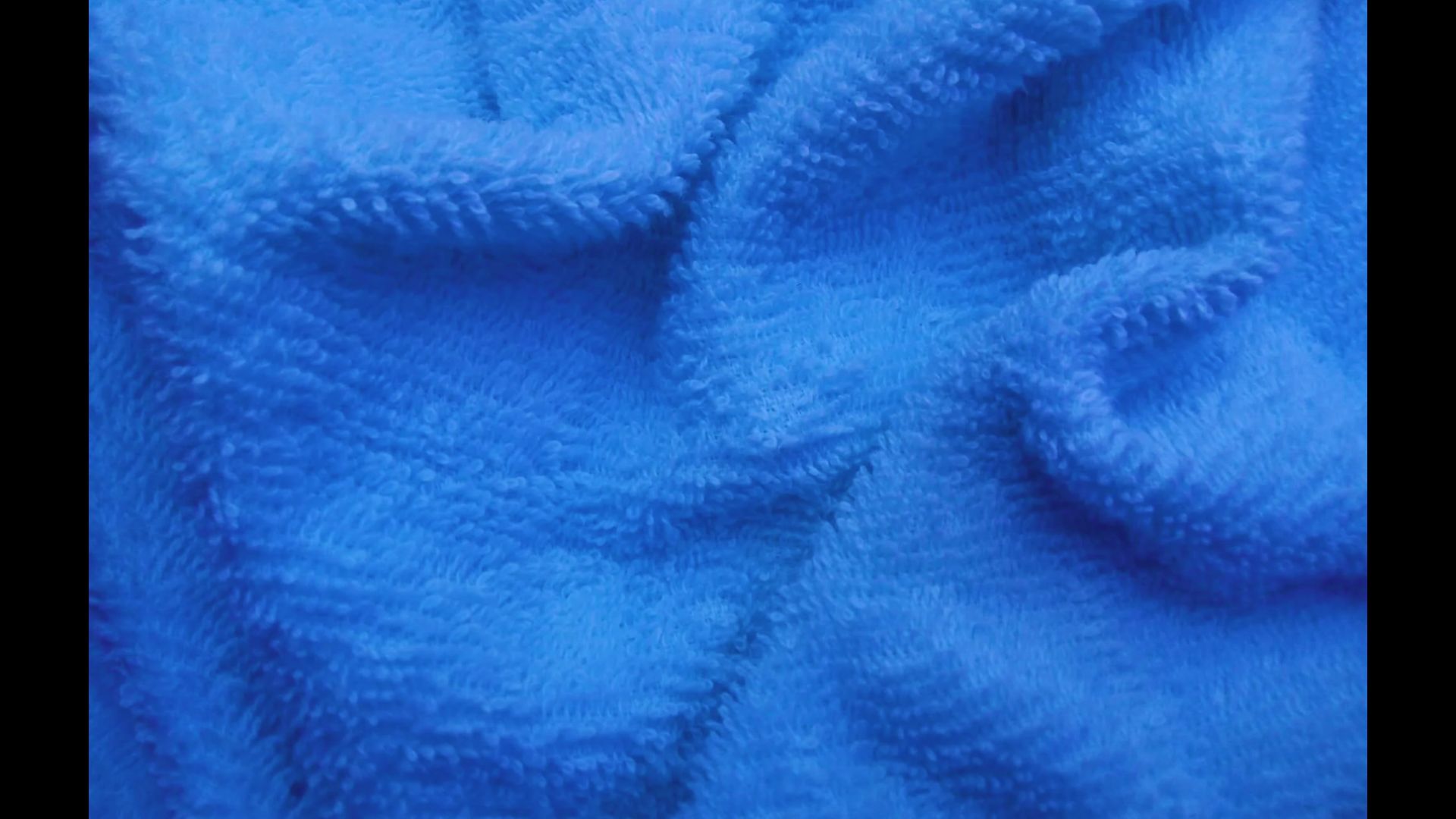 Close-up of a soft, textured static blue fleece blanket.