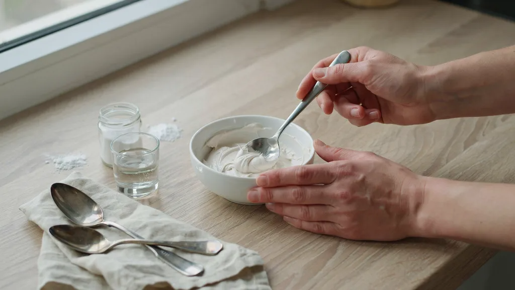 Baking soda paste being mixed in a bowl for polishing silver at home.