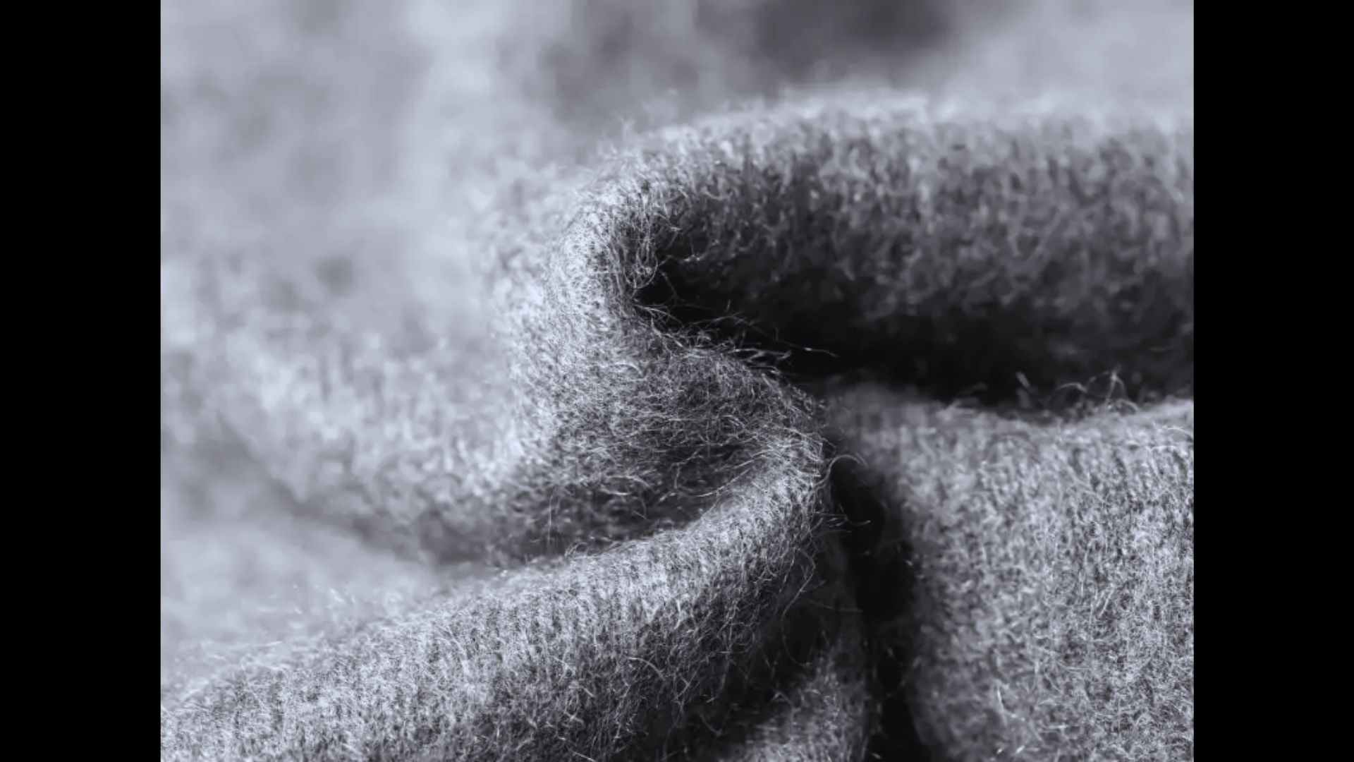 Close-up of a soft, textured static gray fleece blanket.