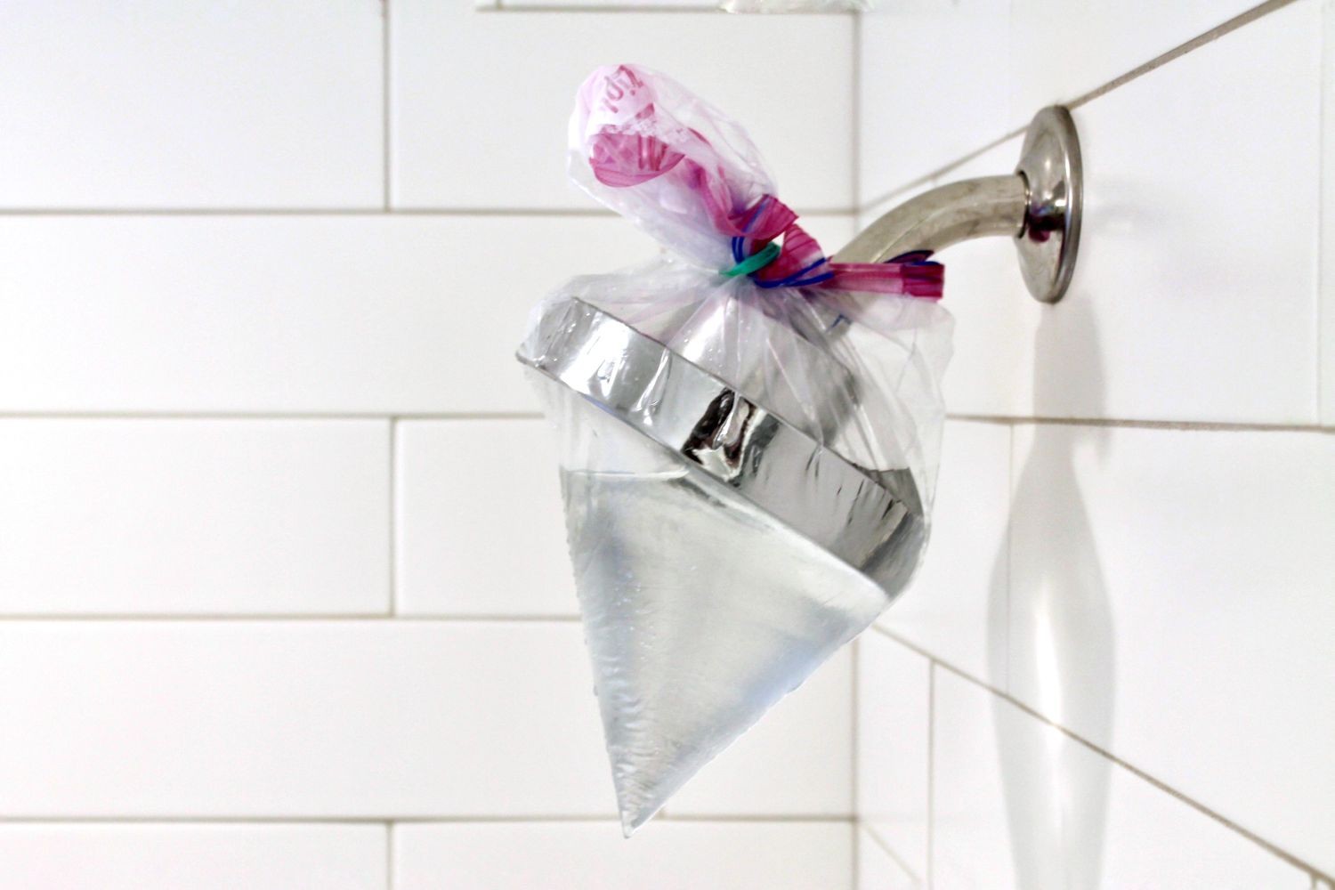 Cleaning a shower head without removing it using a soaking bag method.