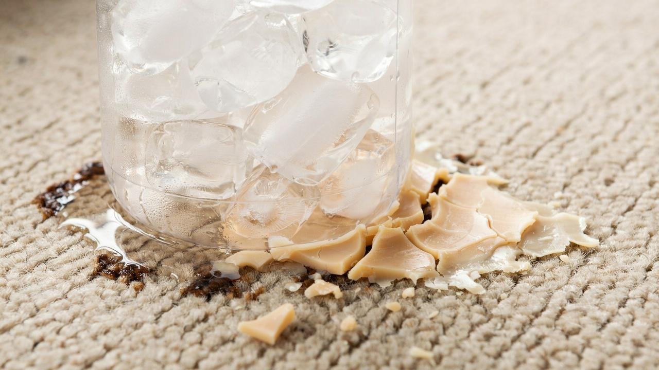 Ice bag freezing candle wax on carpet for easier removal.
